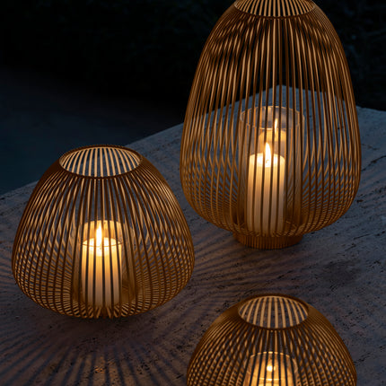 Stalen lantaarns in vorm van tulp van Blomus Lyva in kleur Nomad lichtbruin met brandende kaarsen voor sfeerimpressie