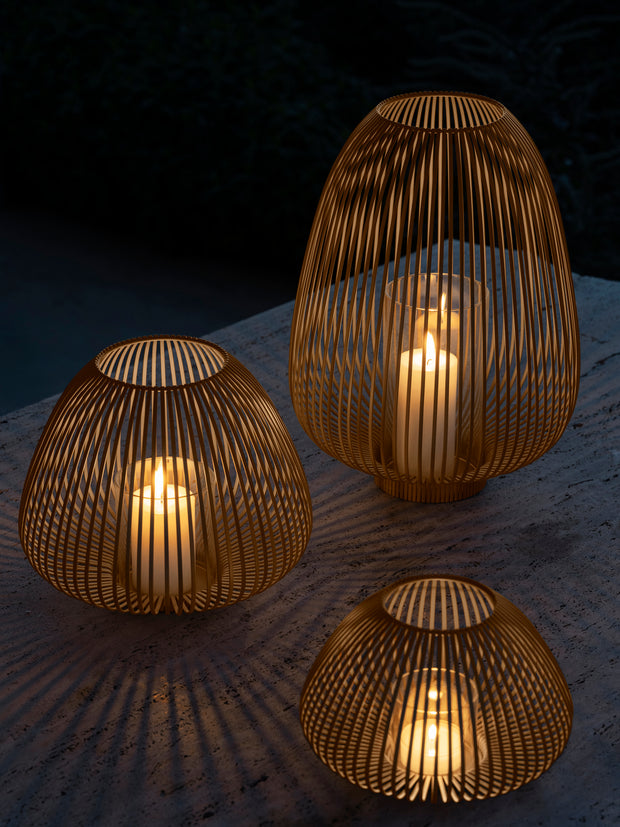 Stalen lantaarns in vorm van tulp van Blomus Lyva in kleur Nomad lichtbruin met brandende kaarsen voor sfeerimpressie