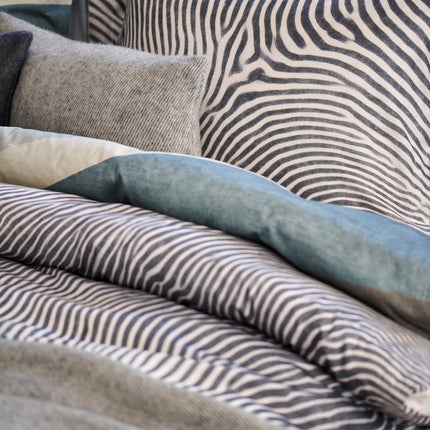 Vandyck satijn katoenen dekbedovertrek met zebraprint en wollen grijze sierkussensloop en sprei met franjes